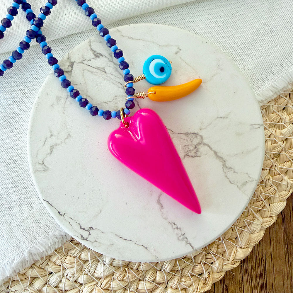 Detalle de cristales y dijes del collar fucsia